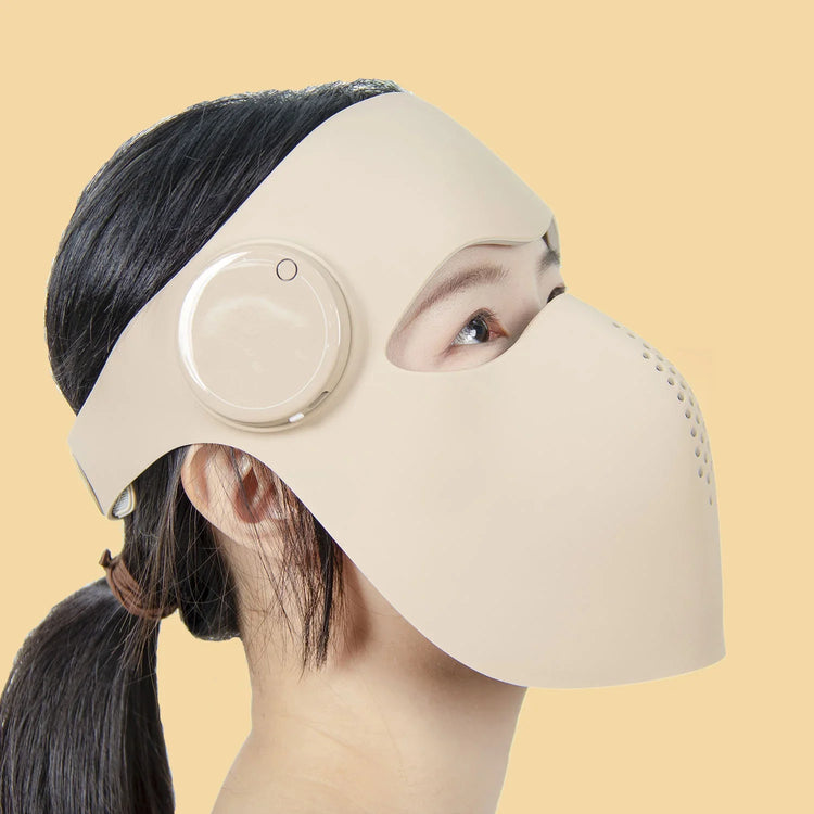 Mujer usando mascarilla LED de fototerapia Lumiskin PRO para cuidado facial en casa.
